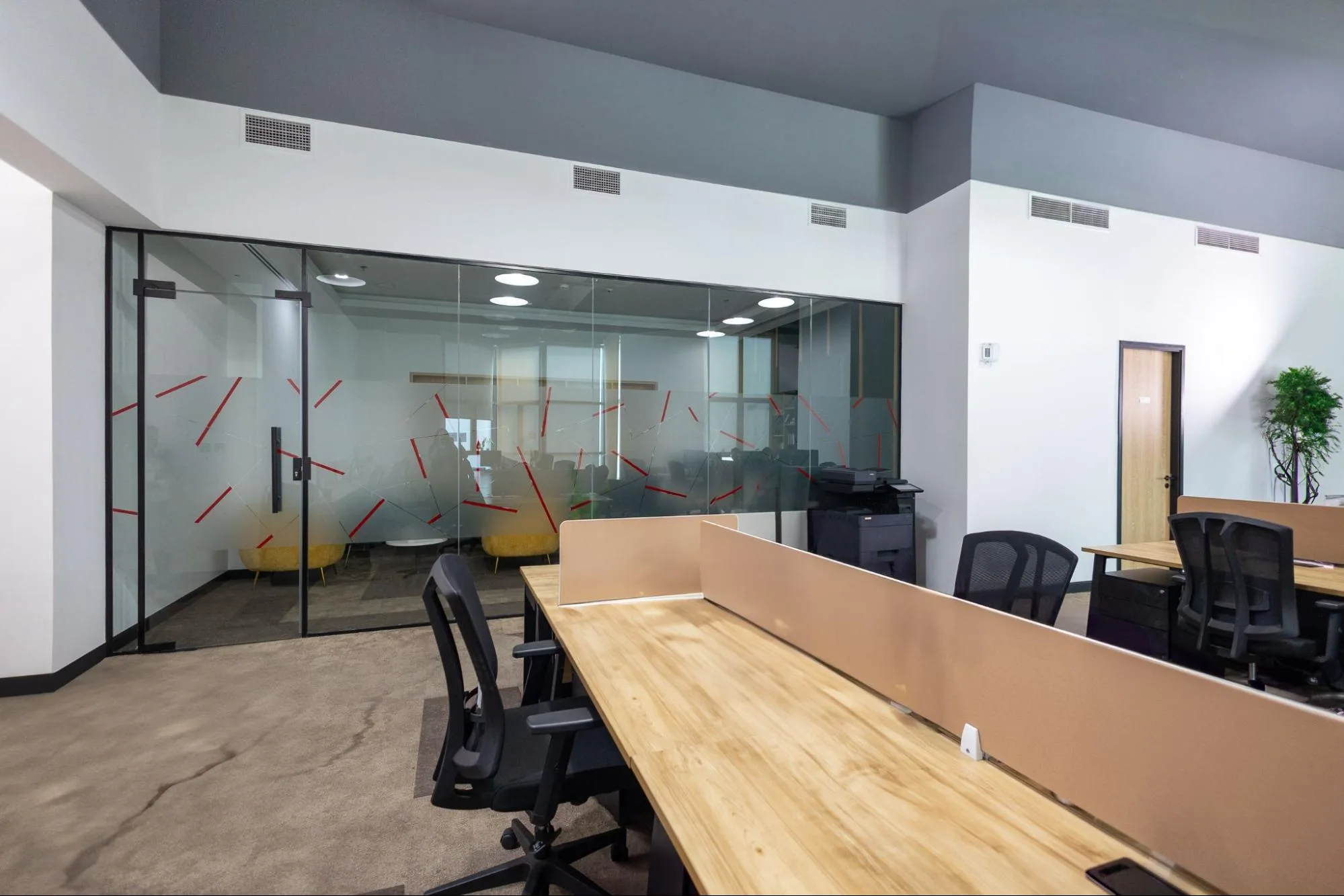  A modern serviced office in Austria Business Center with a glass-walled conference room and rows of desks. 